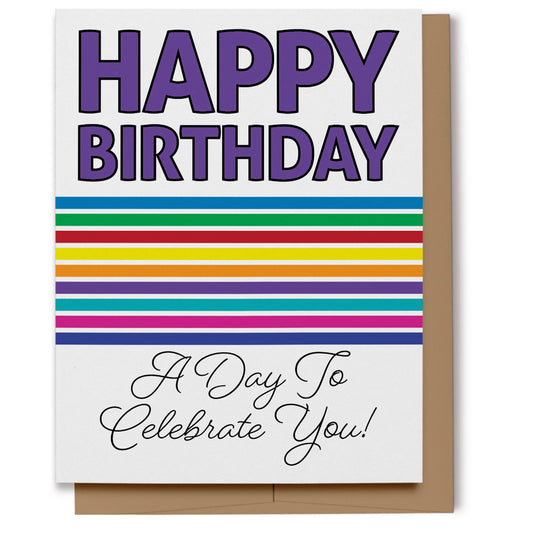 Bold Rainbow Happy Birthday Card has big bold purple letters at the top saying "Happy Birthday" with rainbow-colored stripes beneath and scripted text that reads, "A Day To Celebrate You!"