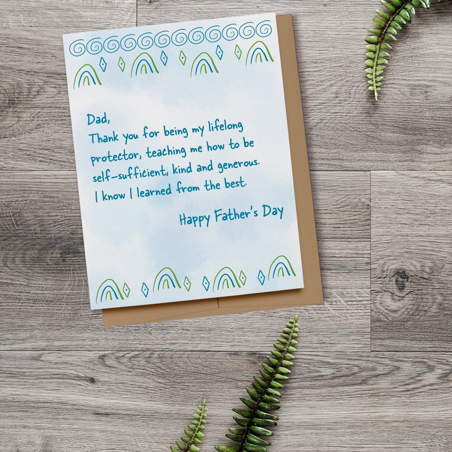 Simple Father's Day cards that reads, "Dad, Thank you for being my lifelong protector, teaching me how to be self-sufficient, kind and generous. I know I learned from the best. Happy Father's Day." Displayed on a wood background with fern leaves.