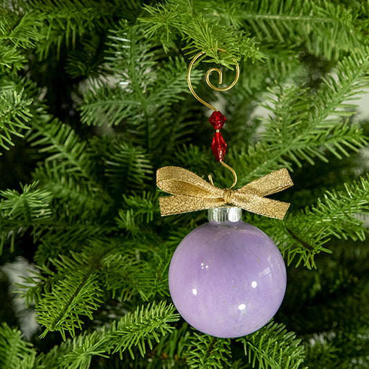 The Jessica Hand Painted Glass Ball Ornament is purple with a hint of metallic gold, white, shimmering silver and a gold shimmer ribbon. Painted using fluid acrylic and acrylic paints. Displayed on a Christmas tree.