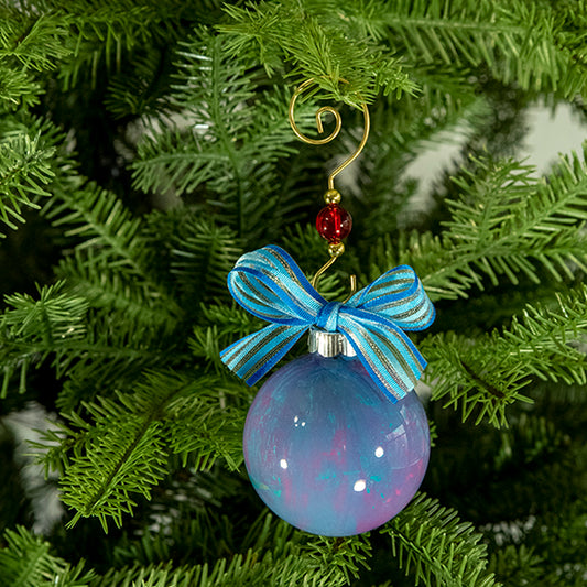 The Cindy Hand Painted Glass Ball Ornament is a mix of blue, pink and purple with a hint of metallic silver and a blue striped shimmer ribbon. Painted using fluid acrylic and acrylic paints. Displayed on a Christmas tree.